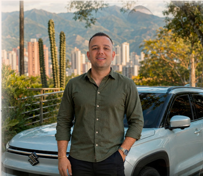 Carlos Cárdenas junto a su vehículo con vista a Medellín