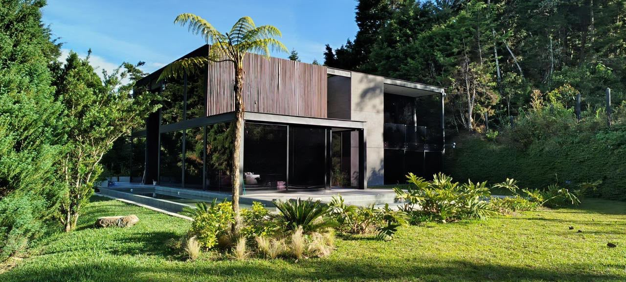 Casa moderna de vidrio y madera rodeada de bosque en Guarne, cerca de Medellín